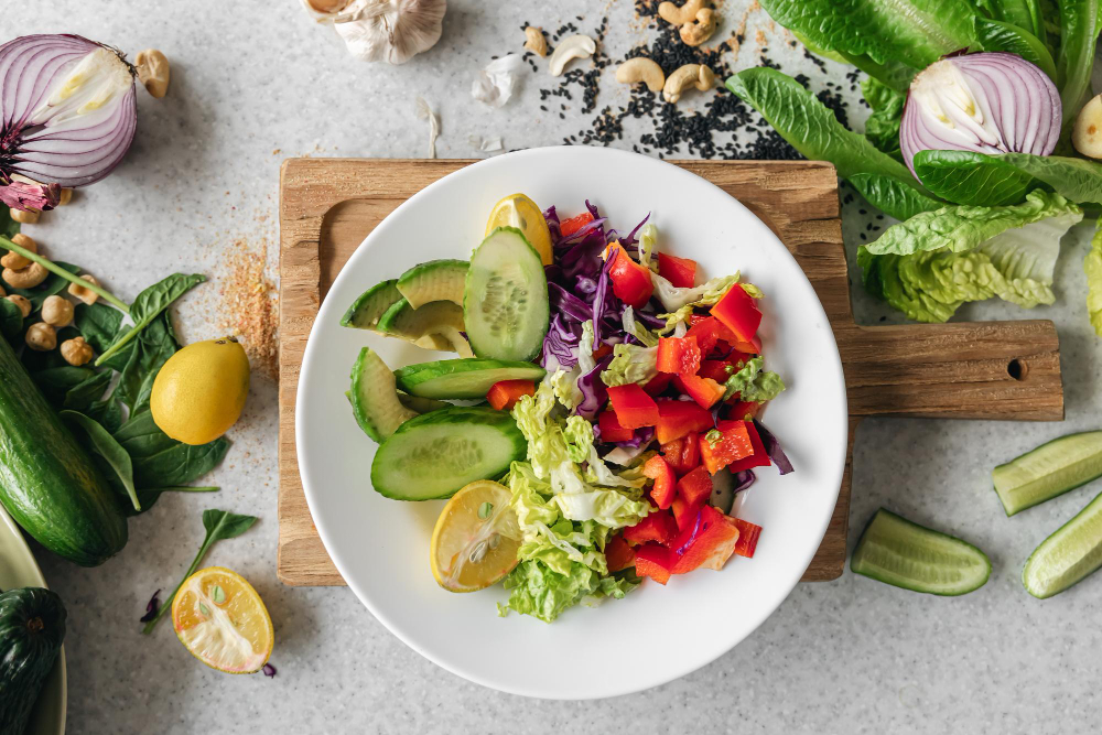 A bowl filled with a variety of fresh vegetables on a table, exemplifying the diversity of a vegan diet